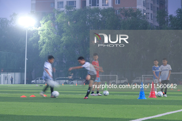 Children practice soccer at the evening soccer field of Capital Sport University in Beijing, China, on September 9, 2024. 