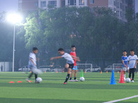 Children practice soccer at the evening soccer field of Capital Sport University in Beijing, China, on September 9, 2024. (