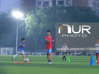 Children practice soccer at the evening soccer field of Capital Sport University in Beijing, China, on September 9, 2024. (