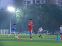 Children practice soccer at the evening soccer field of Capital Sport University in Beijing, China, on September 9, 2024. (