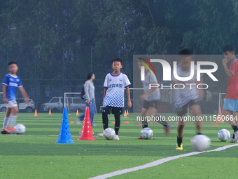 Children practice soccer at the evening soccer field of Capital Sport University in Beijing, China, on September 9, 2024. (