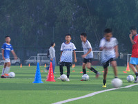 Children practice soccer at the evening soccer field of Capital Sport University in Beijing, China, on September 9, 2024. (