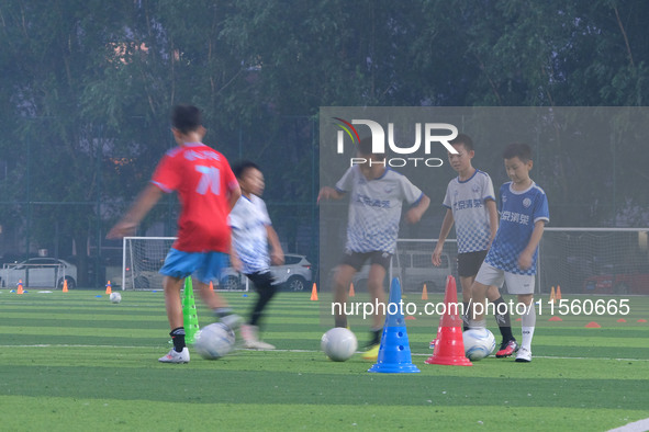 Children practice soccer at the evening soccer field of Capital Sport University in Beijing, China, on September 9, 2024. 