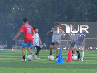 Children practice soccer at the evening soccer field of Capital Sport University in Beijing, China, on September 9, 2024. (