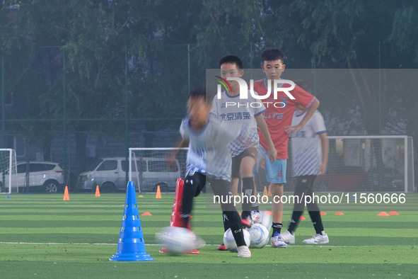 Children practice soccer at the evening soccer field of Capital Sport University in Beijing, China, on September 9, 2024. 