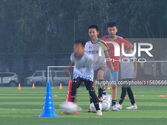 Children practice soccer at the evening soccer field of Capital Sport University in Beijing, China, on September 9, 2024. (