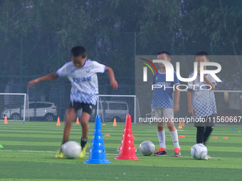 Children practice soccer at the evening soccer field of Capital Sport University in Beijing, China, on September 9, 2024. (