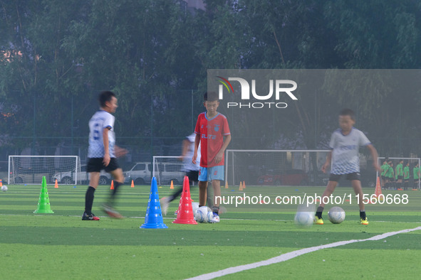 Children practice soccer at the evening soccer field of Capital Sport University in Beijing, China, on September 9, 2024. 