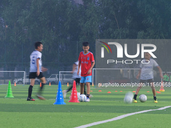 Children practice soccer at the evening soccer field of Capital Sport University in Beijing, China, on September 9, 2024. (