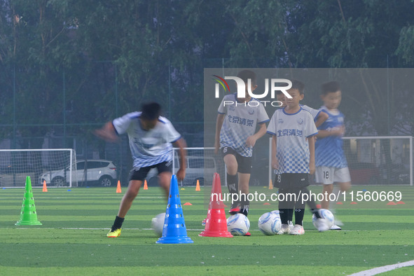 Children practice soccer at the evening soccer field of Capital Sport University in Beijing, China, on September 9, 2024. 