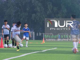 Children practice soccer at the evening soccer field of Capital Sport University in Beijing, China, on September 9, 2024. (