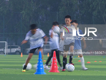 Children practice soccer at the evening soccer field of Capital Sport University in Beijing, China, on September 9, 2024. (