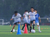 Children practice soccer at the evening soccer field of Capital Sport University in Beijing, China, on September 9, 2024. (