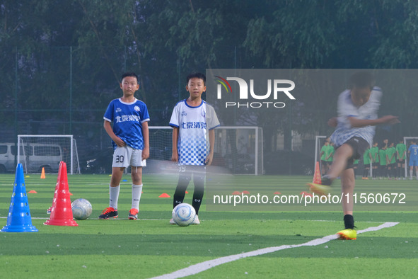 Children practice soccer at the evening soccer field of Capital Sport University in Beijing, China, on September 9, 2024. 