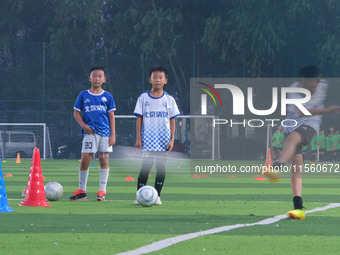 Children practice soccer at the evening soccer field of Capital Sport University in Beijing, China, on September 9, 2024. (