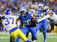 DETROIT,MICHIGAN-SEPTEMBER 8:  Running back Jahmyr Gibbs (26) of the Detroit Lions carries the ball under the pressure of safety Quentin Lak...