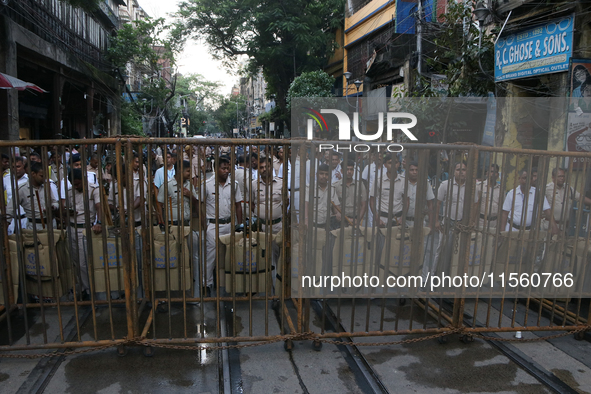 Police officials stand guard while Left Party members shout slogans during a protest rally towards Kolkata Police Headquarters, Lalbazar, to...