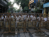 Police officials stand guard while Left Party members shout slogans during a protest rally towards Kolkata Police Headquarters, Lalbazar, to...