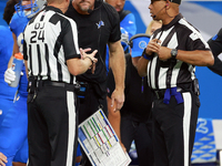 DETROIT,MICHIGAN-SEPTEMBER 8:   Down judge David Oliver (24) and back judge Greg Steed (12)  talk with head coach Dan Campbell during a game...