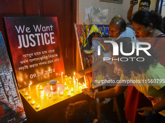 People light candles in solidarity with the victim of rape and murder at RG Kar Medical College, as seen at the iconic India Coffee House in...