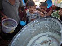 Displaced Palestinian children wait at a food distribution point in Deir el-Balah, Gaza Strip, on September 9, 2024, amid the ongoing confli...