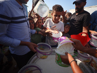 Displaced Palestinian children wait at a food distribution point in Deir el-Balah, Gaza Strip, on September 9, 2024, amid the ongoing confli...