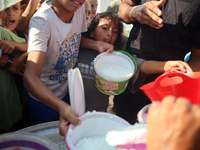 Displaced Palestinian children wait at a food distribution point in Deir el-Balah, Gaza Strip, on September 9, 2024, amid the ongoing confli...