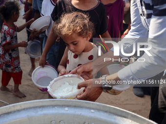 Displaced Palestinian children wait at a food distribution point in Deir el-Balah, Gaza Strip, on September 9, 2024, amid the ongoing confli...