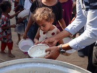 Displaced Palestinian children wait at a food distribution point in Deir el-Balah, Gaza Strip, on September 9, 2024, amid the ongoing confli...