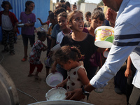 Displaced Palestinian children wait at a food distribution point in Deir el-Balah, Gaza Strip, on September 9, 2024, amid the ongoing confli...