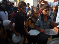 Displaced Palestinian children wait at a food distribution point in Deir el-Balah, Gaza Strip, on September 9, 2024, amid the ongoing confli...