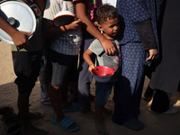 Displaced Palestinian children wait at a food distribution point in Deir el-Balah, Gaza Strip, on September 9, 2024, amid the ongoing confli...