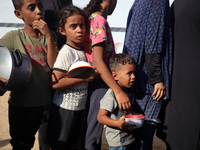 Displaced Palestinian children wait at a food distribution point in Deir el-Balah, Gaza Strip, on September 9, 2024, amid the ongoing confli...