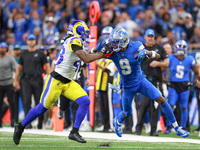 DETROIT,MICHIGAN-SEPTEMBER 8:  Wide receiver Jameson Williams (9) of the Detroit Lions runs the ball under the pressure of safety John Johns...