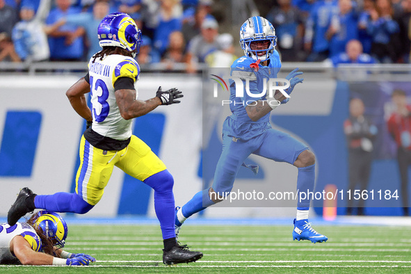 DETROIT,MICHIGAN-SEPTEMBER 8:  Wide receiver Jameson Williams (9) of the Detroit Lions runs the ball under the pressure of safety John Johns...