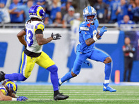 DETROIT,MICHIGAN-SEPTEMBER 8:  Wide receiver Jameson Williams (9) of the Detroit Lions runs the ball under the pressure of safety John Johns...