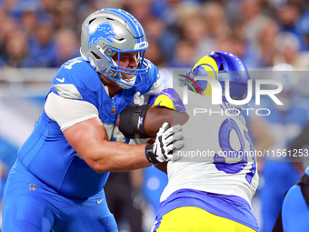 DETROIT,MICHIGAN-SEPTEMBER 8:  Defensive tackle Kobie Turner (91) of the Los Angeles Rams holds the line against guard Kevin Zeitler (71) of...