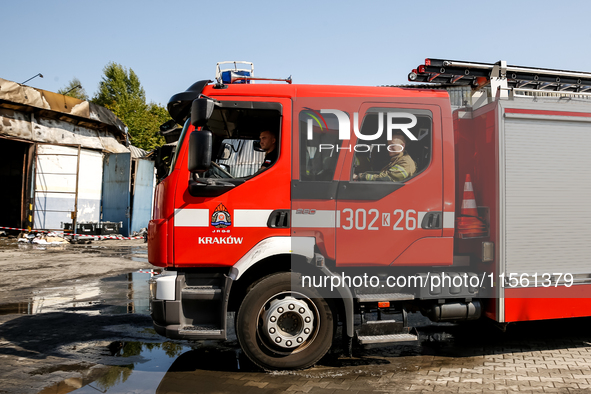 Firefighters are seen in front of a burned warehouse in southern Krakow as it burned in the night on September 7, 2024 in Krakow, Poland. Th...