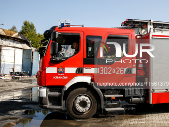 Firefighters are seen in front of a burned warehouse in southern Krakow as it burned in the night on September 7, 2024 in Krakow, Poland. Th...