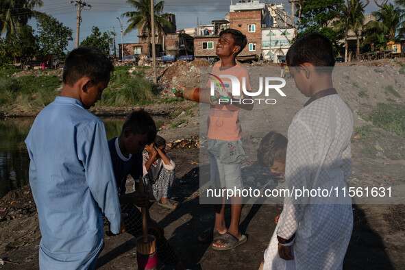 Kids play with kites near a polluted canal of the Buriganga River in Dhaka, Bangladesh, on September 9, 2024. 