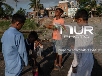 Kids play with kites near a polluted canal of the Buriganga River in Dhaka, Bangladesh, on September 9, 2024. (