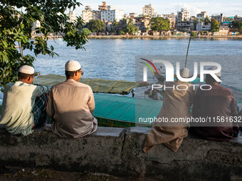 Muslim religious people sit on a bench by the riverside in Dhaka, Bangladesh, on September 9, 2024. (