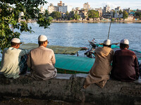 Muslim religious people sit on a bench by the riverside in Dhaka, Bangladesh, on September 9, 2024. (