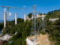 Electric power employees work on a steel tower near the Shuigang Railway in Xikouping village, Yichang city, Central China's Hubei province,...