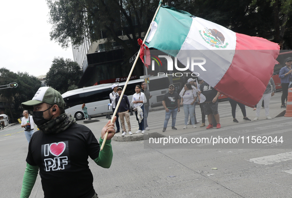 A judiciary worker waves a Mexican flag while taking part in a rally against the judicial reform proposed by current President Andres Manuel...