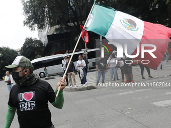 A judiciary worker waves a Mexican flag while taking part in a rally against the judicial reform proposed by current President Andres Manuel...