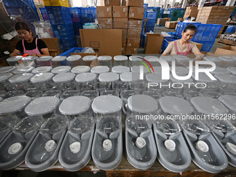 A worker assembles a pet water dispenser at a workshop in Suqian, China, on September 10, 2024. (