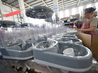 A worker assembles a pet water dispenser at a workshop in Suqian, China, on September 10, 2024. (