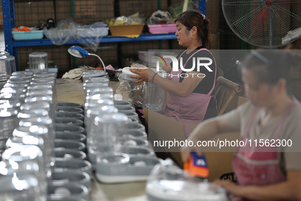 A worker assembles a pet water dispenser at a workshop in Suqian, China, on September 10, 2024. 