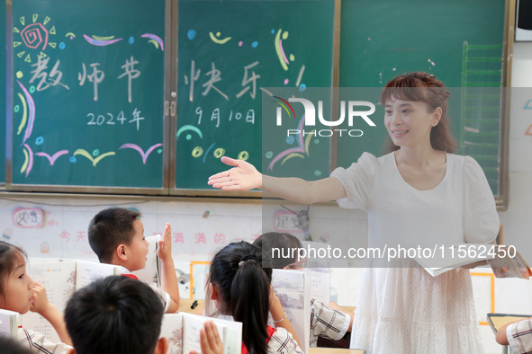 Han Jianrui, a primary school teacher, interacts with students during a ''Teachers' Day themed class meeting'' in Zaozhuang, China, on Septe...